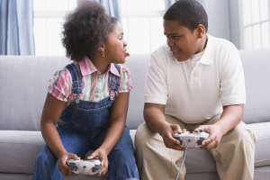 African American sister and brother playing video games