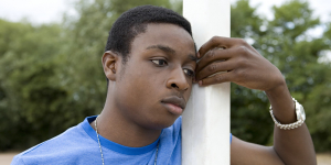 Boy leaning on goalpost