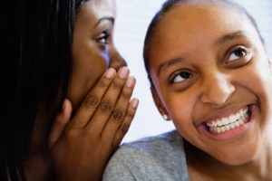 Two Teenage Girls Whispering --- Image by © Corbis